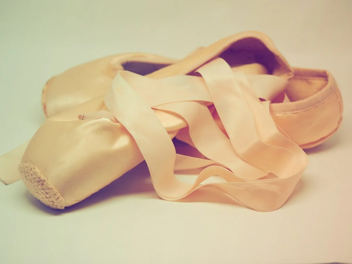 Balletcore styling details: satin ballet flats, ribbon ties, and a blush wrap top