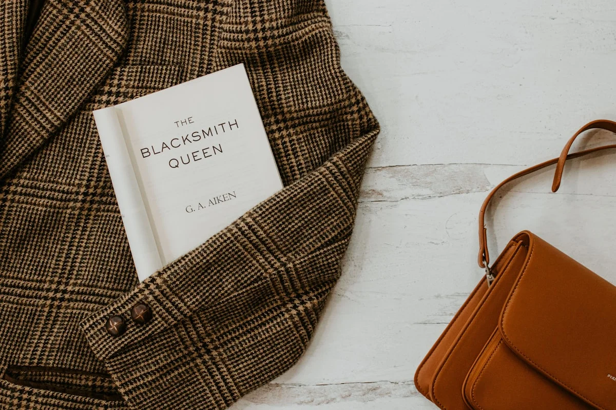 Dark academia styling details: tweed blazer, plaid, leather satchel, and vintage books