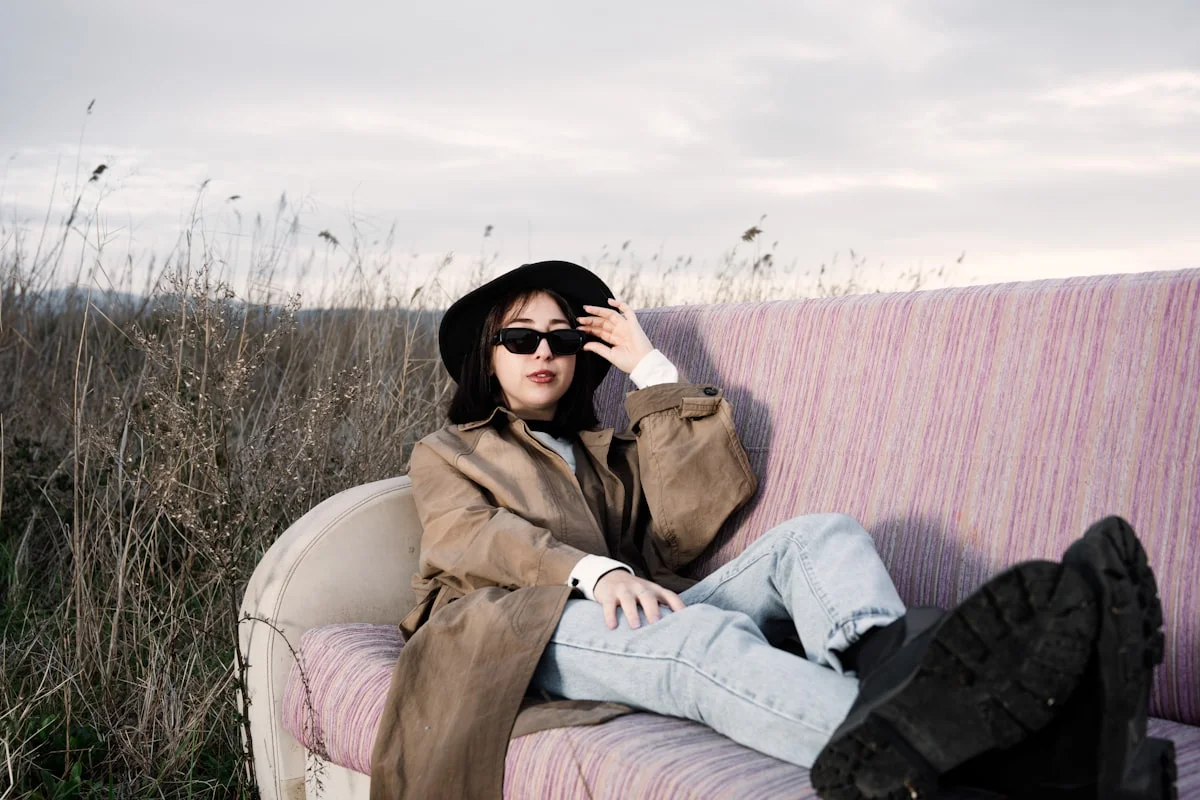 Woman wearing a lightweight spring capsule wardrobe outfit with a trench coat and pastel layers