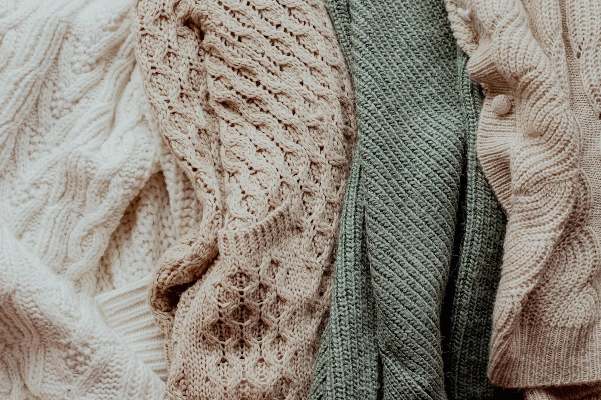 Dusty rose and sage green knitwear flatlay in Soft Summer colors