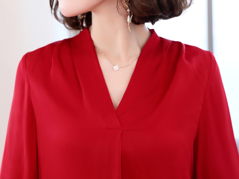 Woman wearing a dressy casual outfit with a flowy top and tailored pants