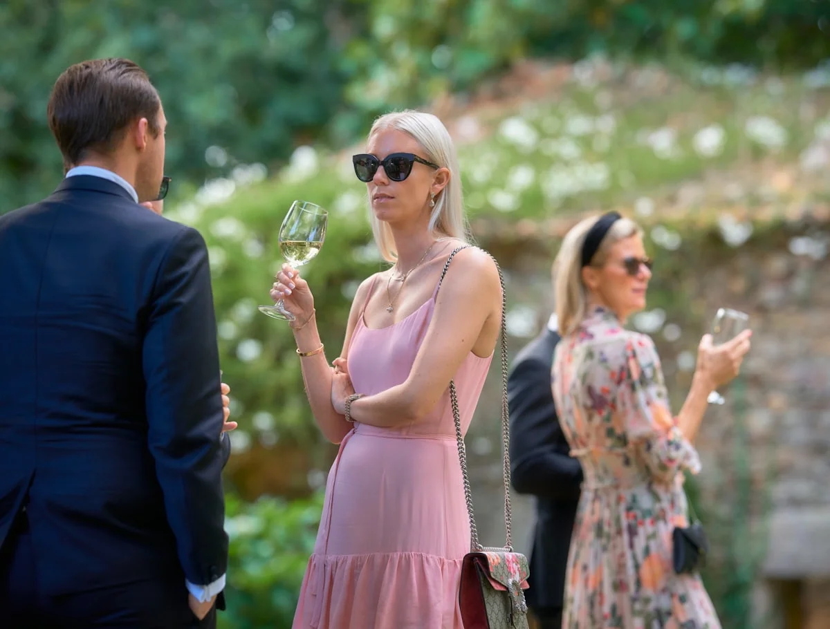 Guests in garden party attire at an outdoor summer event