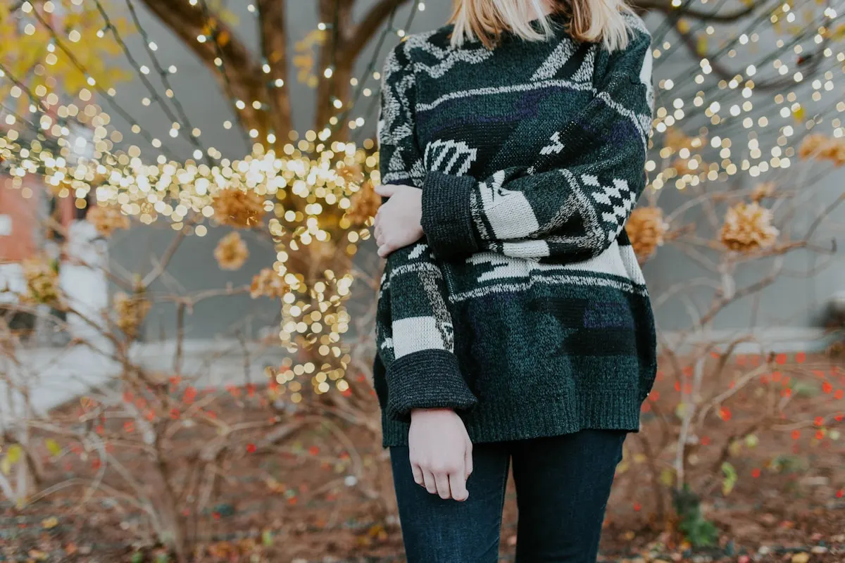 Cozy patterned knit sweater and jeans styled for a Christmas gathering with holiday lights