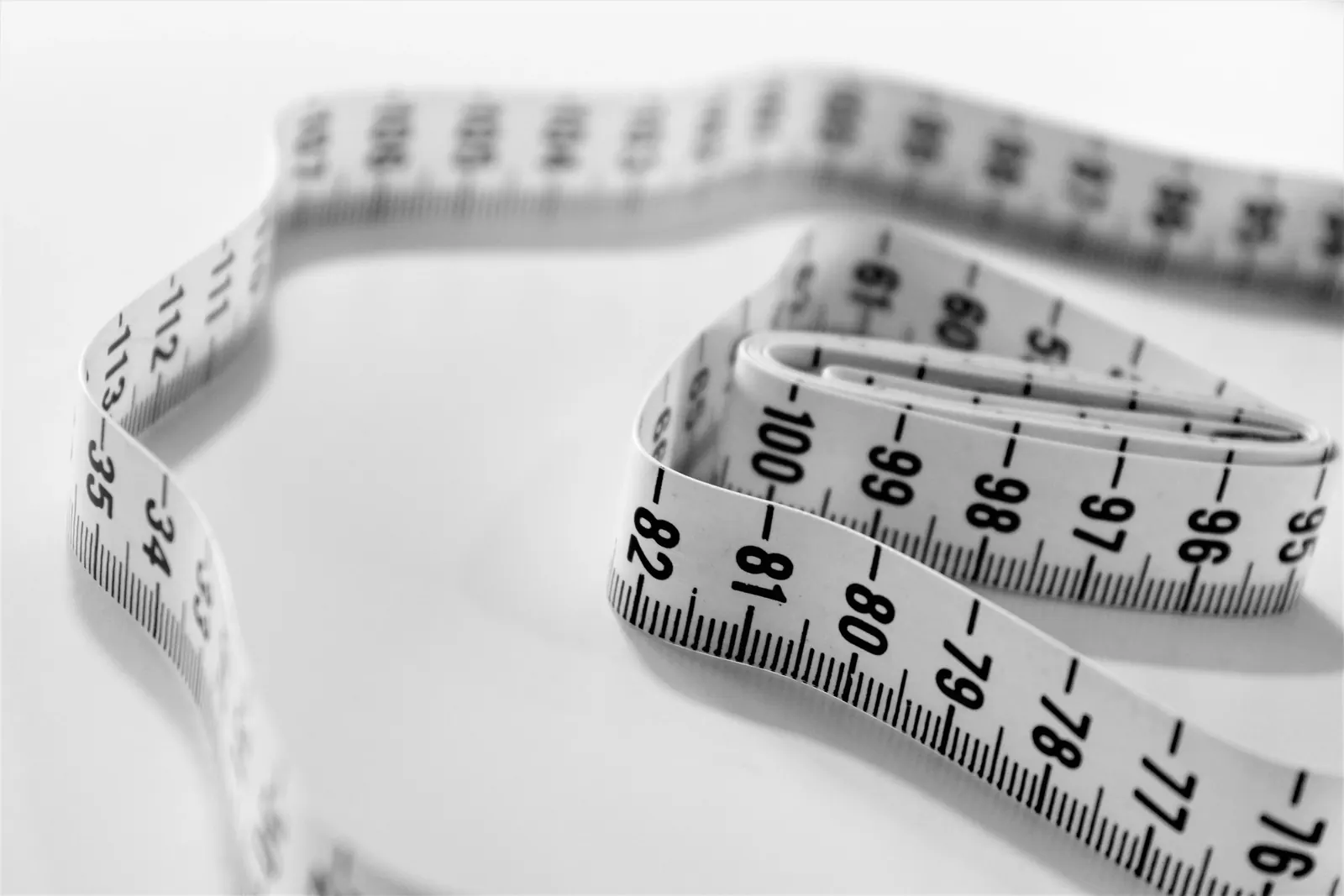 Soft sewing tape measure laid out on a white surface, ready to measure bust, waist, hips, and inseam